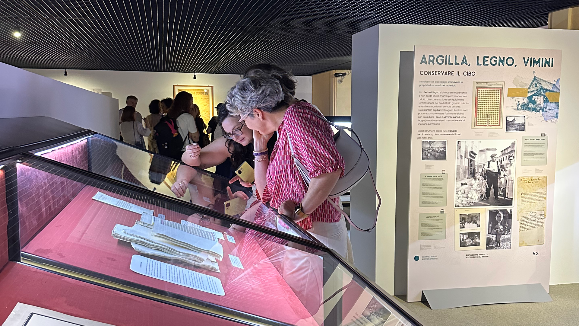 Visitors to the SAGA exhibit examine documents on display