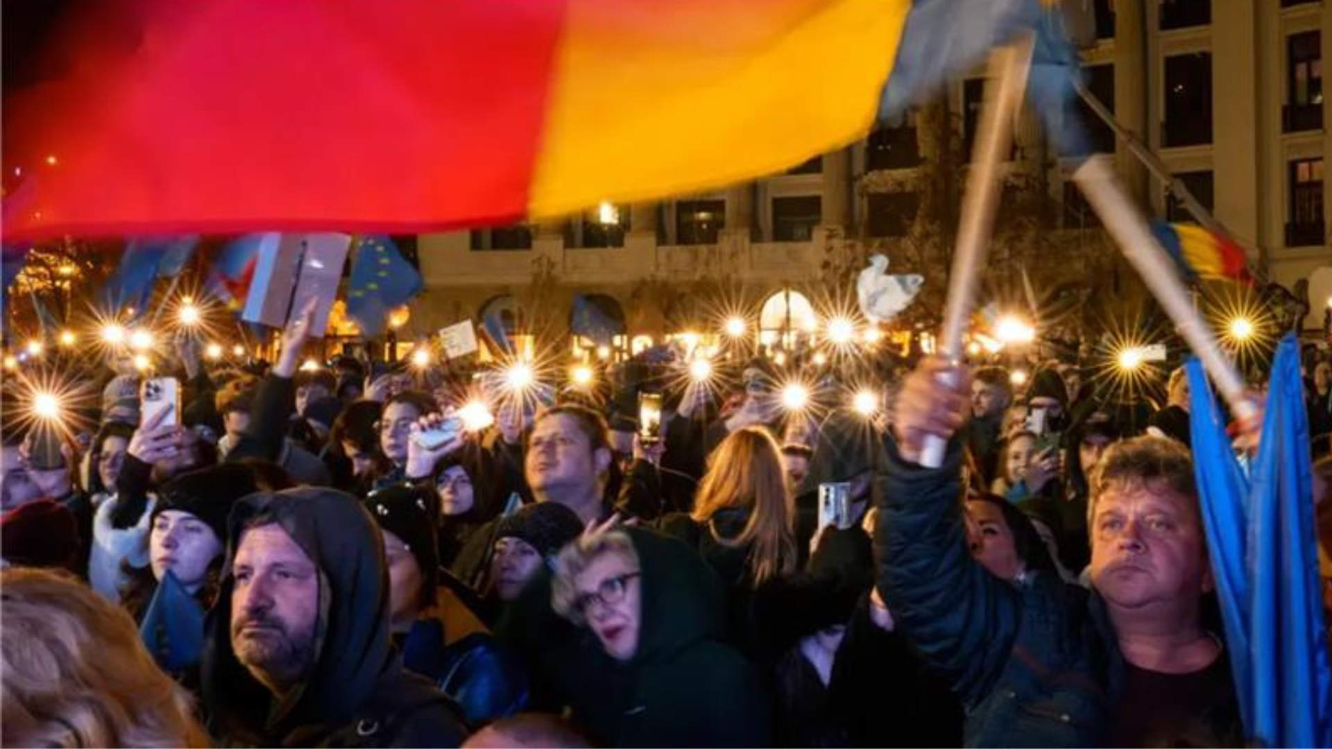 People demonstrating in Romania with the country flag.