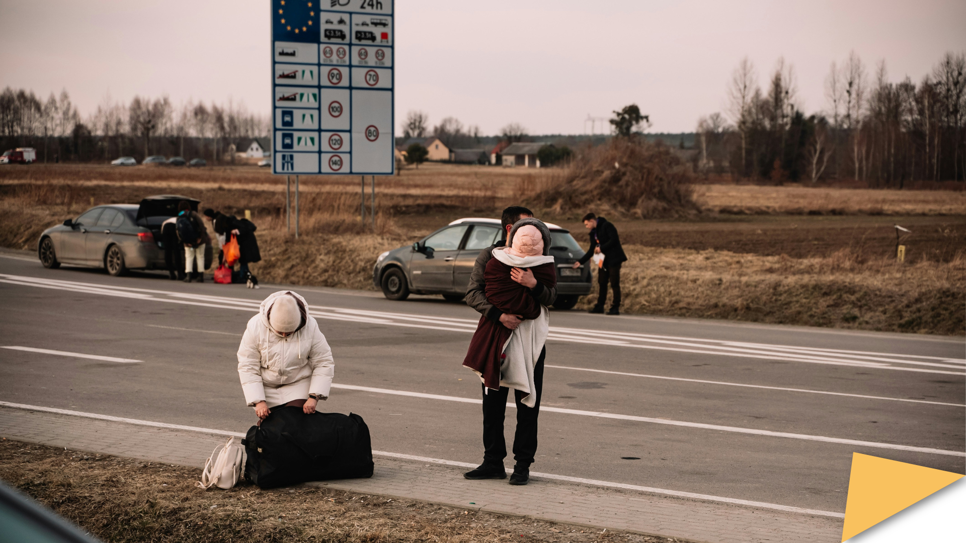 Displaced Ukrainians packing their bags in the middle of a road to enter the European Union.