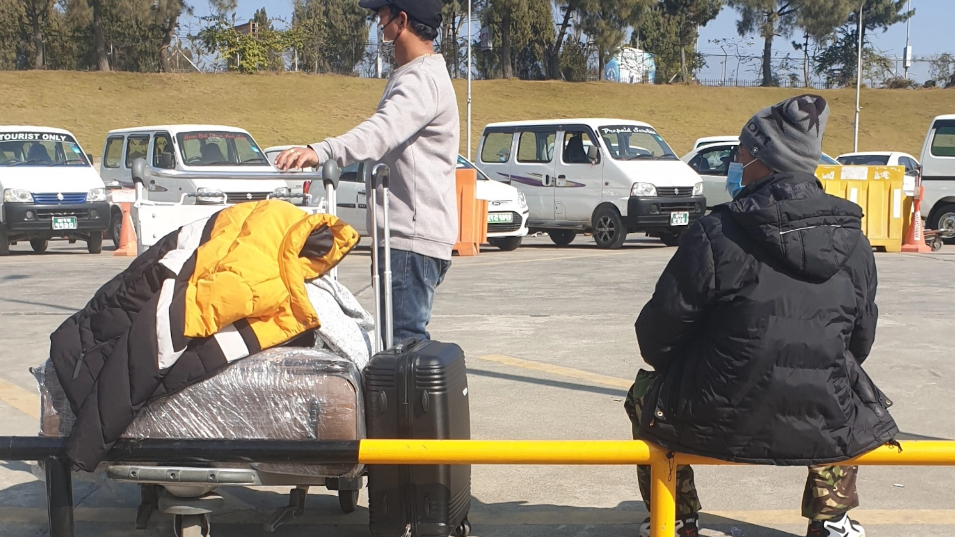 Nepali migrants waiting at a bus stop