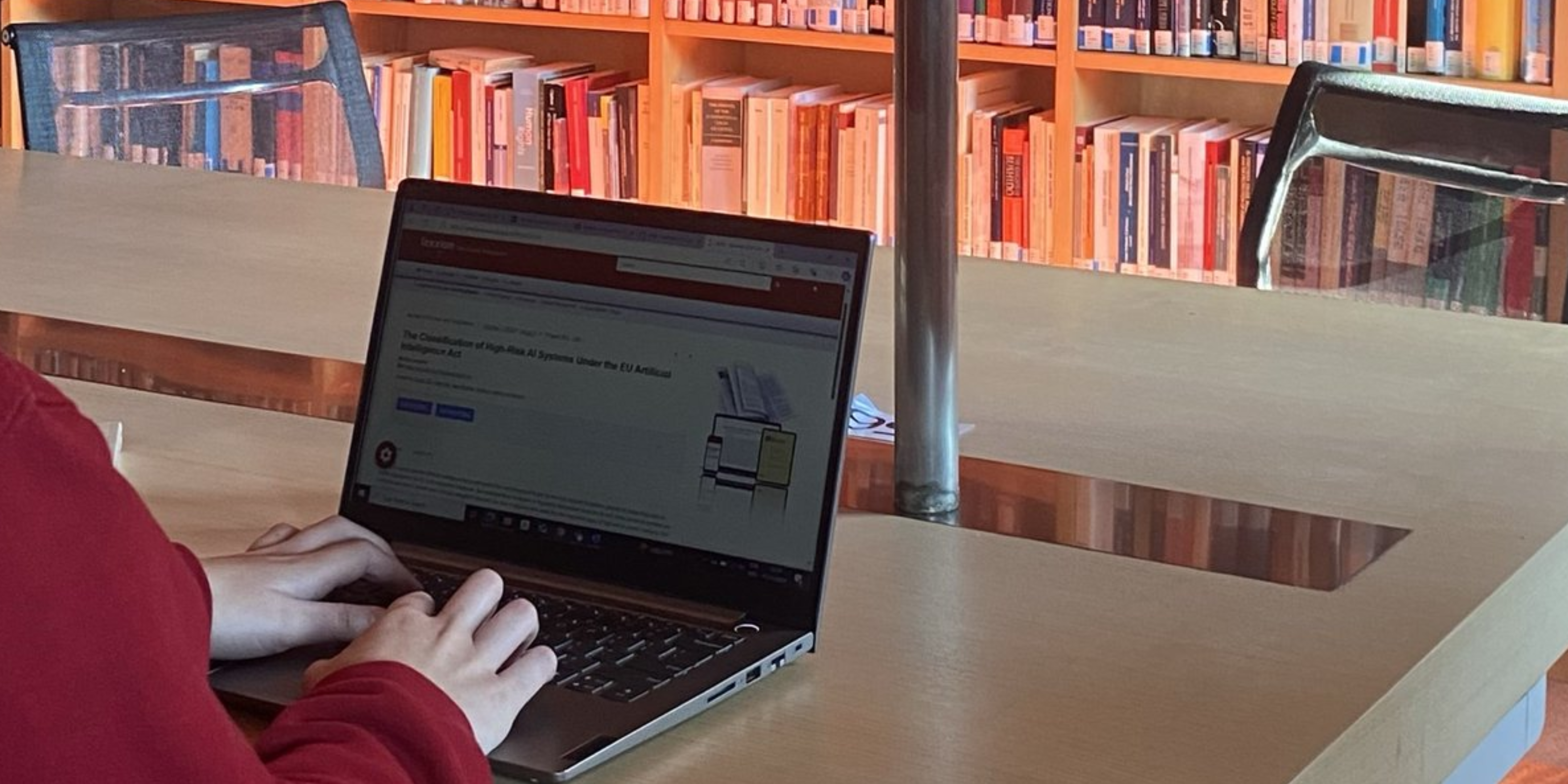 Researcher using a laptop at a study desk in the EUI Library.