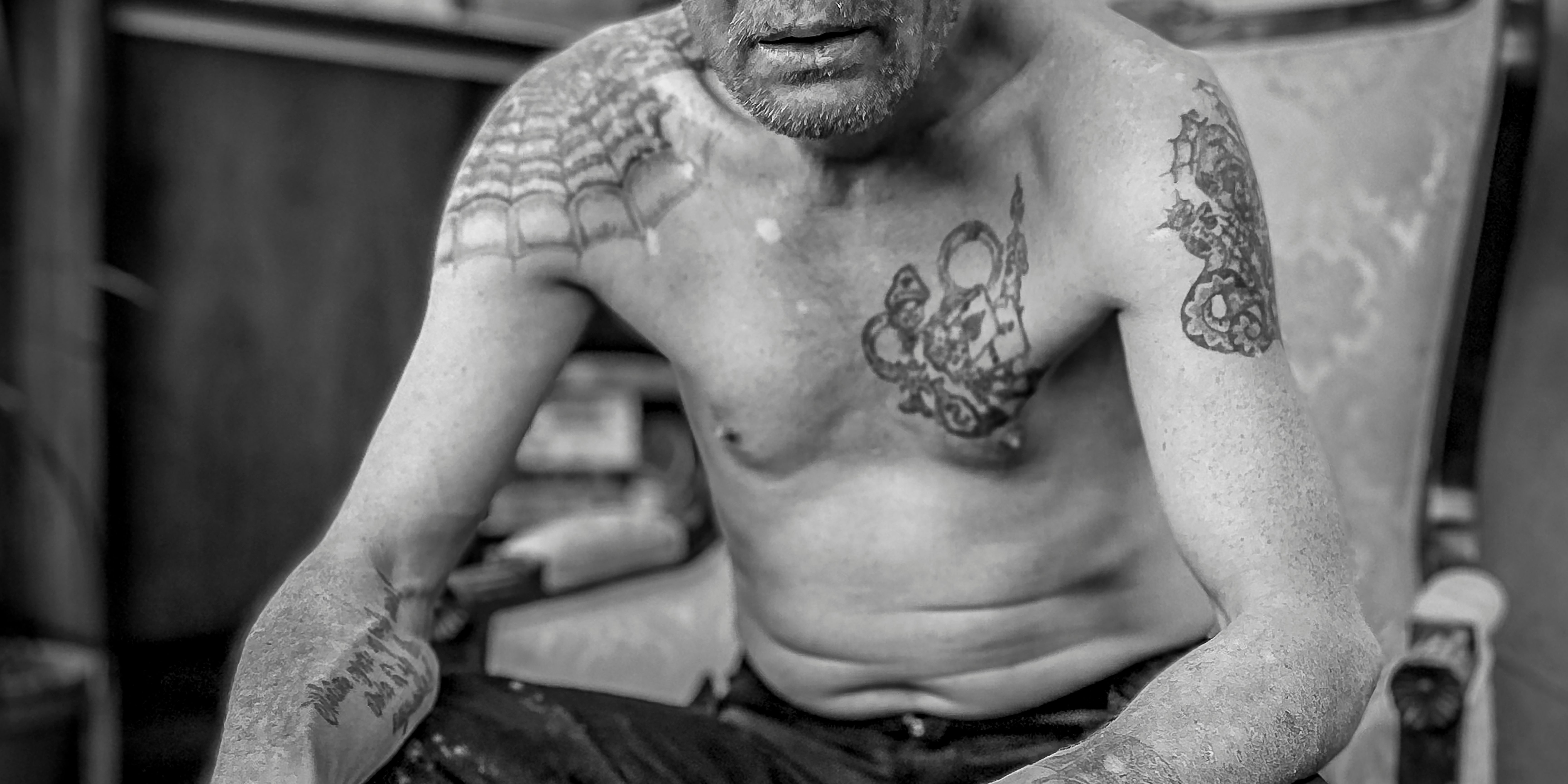 Tattooed torso in black-and-white close-up. Photograph by Nicolas Wieers and b/w David Vannucci. 