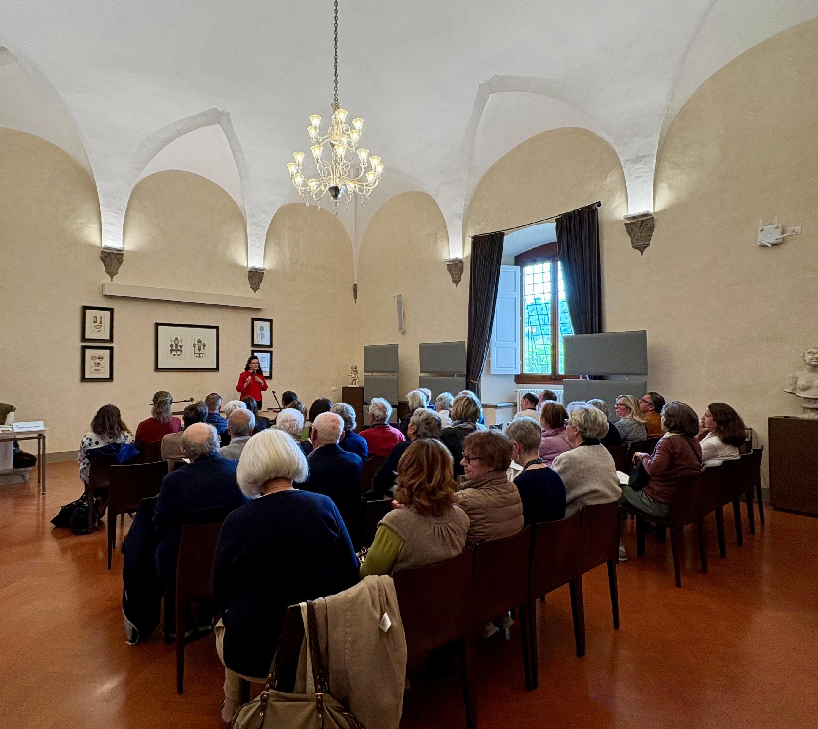Sala Buonsanti, Badia Fiesolana, one person standing presenting to audience in attendance