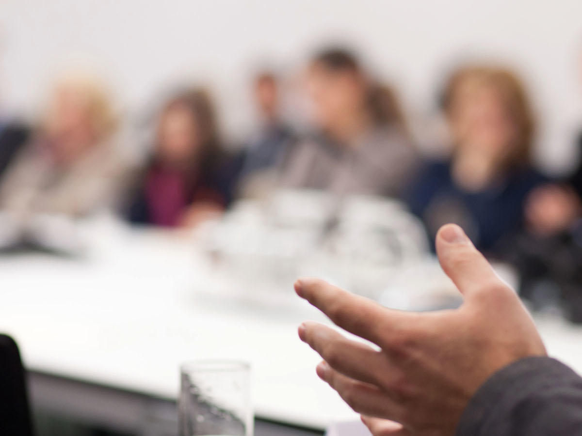 Hands in foreground during a conference