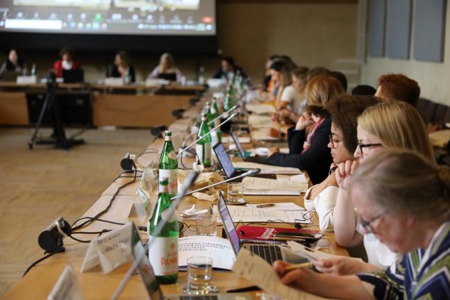 People sitting in row during conference with screen in background