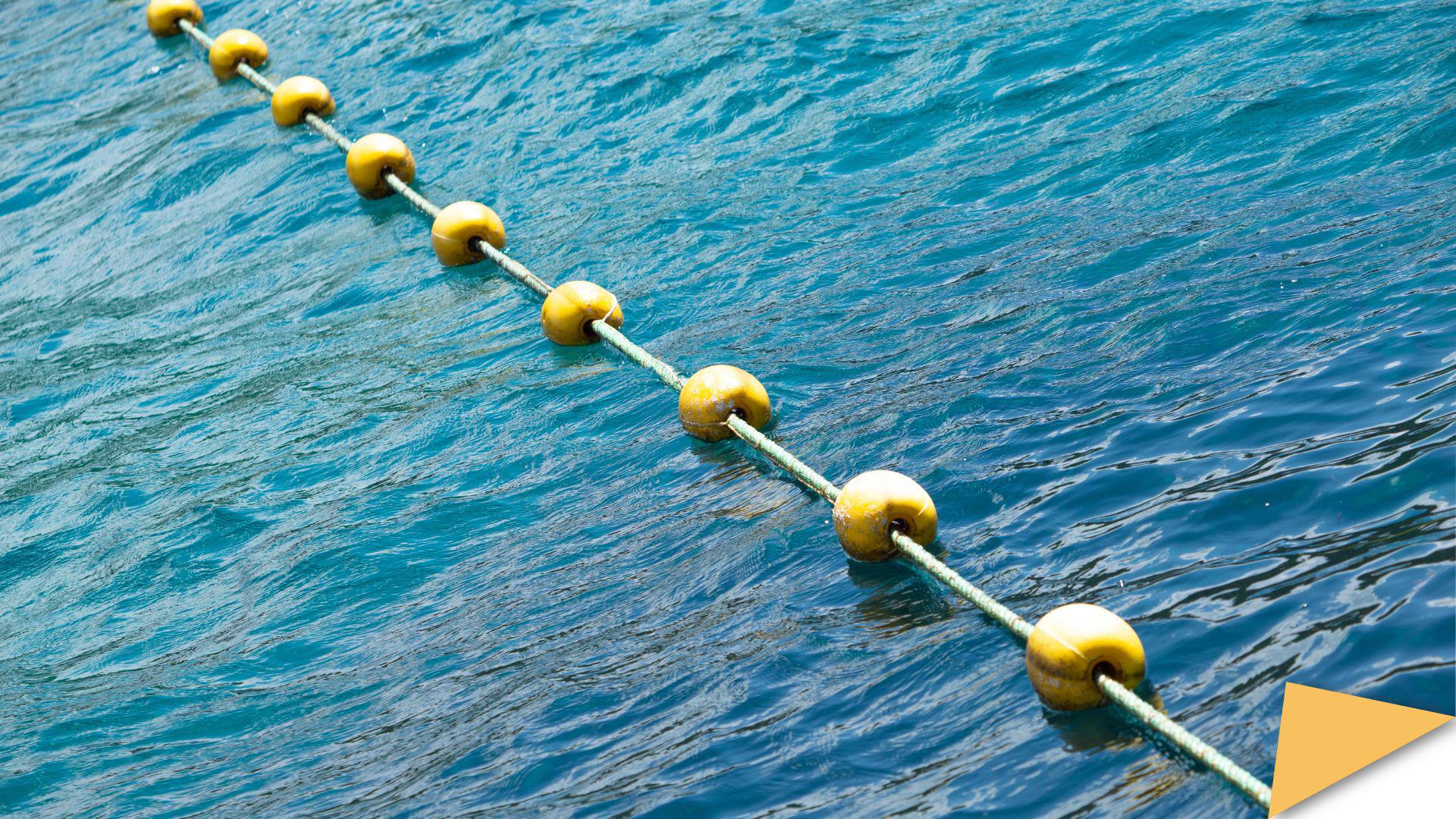 A yellow sea buoy placed diagonally over the blue sea
