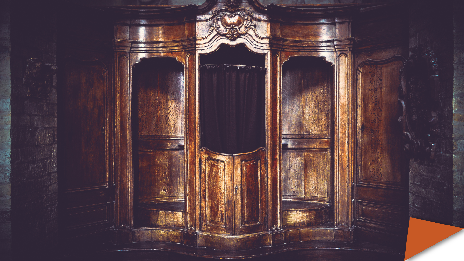 A large, ornately carved wooden confessional booth inside a dimly lit church, with heavy dark curtains drawn across the central compartment. The polished wood panels and decorative details evoke an early modern religious setting.