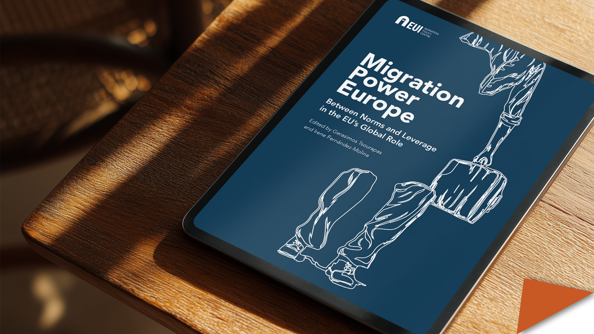 Cover of the volume 'Migration Power Europe' on a digital device on a wooden table.
