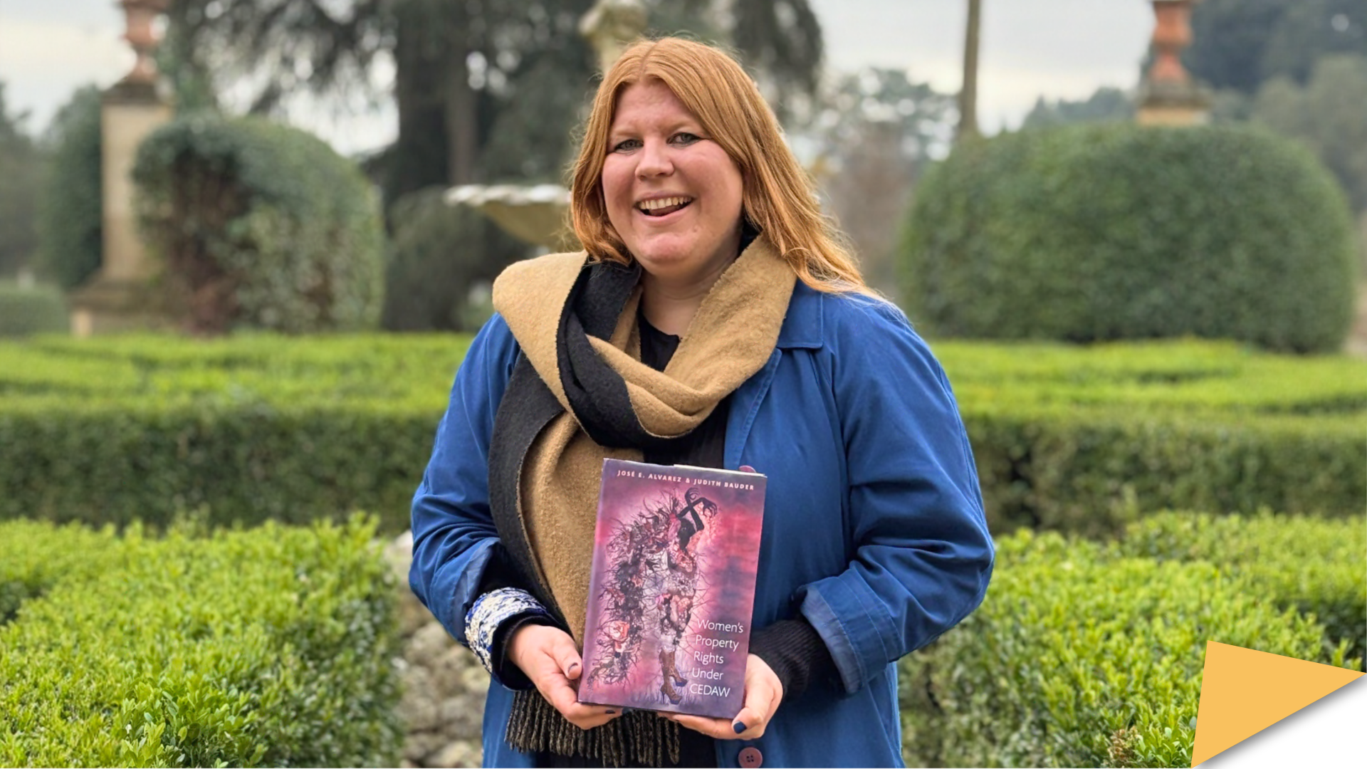 Judith Bauder holds her book Women’s Property Rights under CEDAW while standing in a garden at the European University Institute.