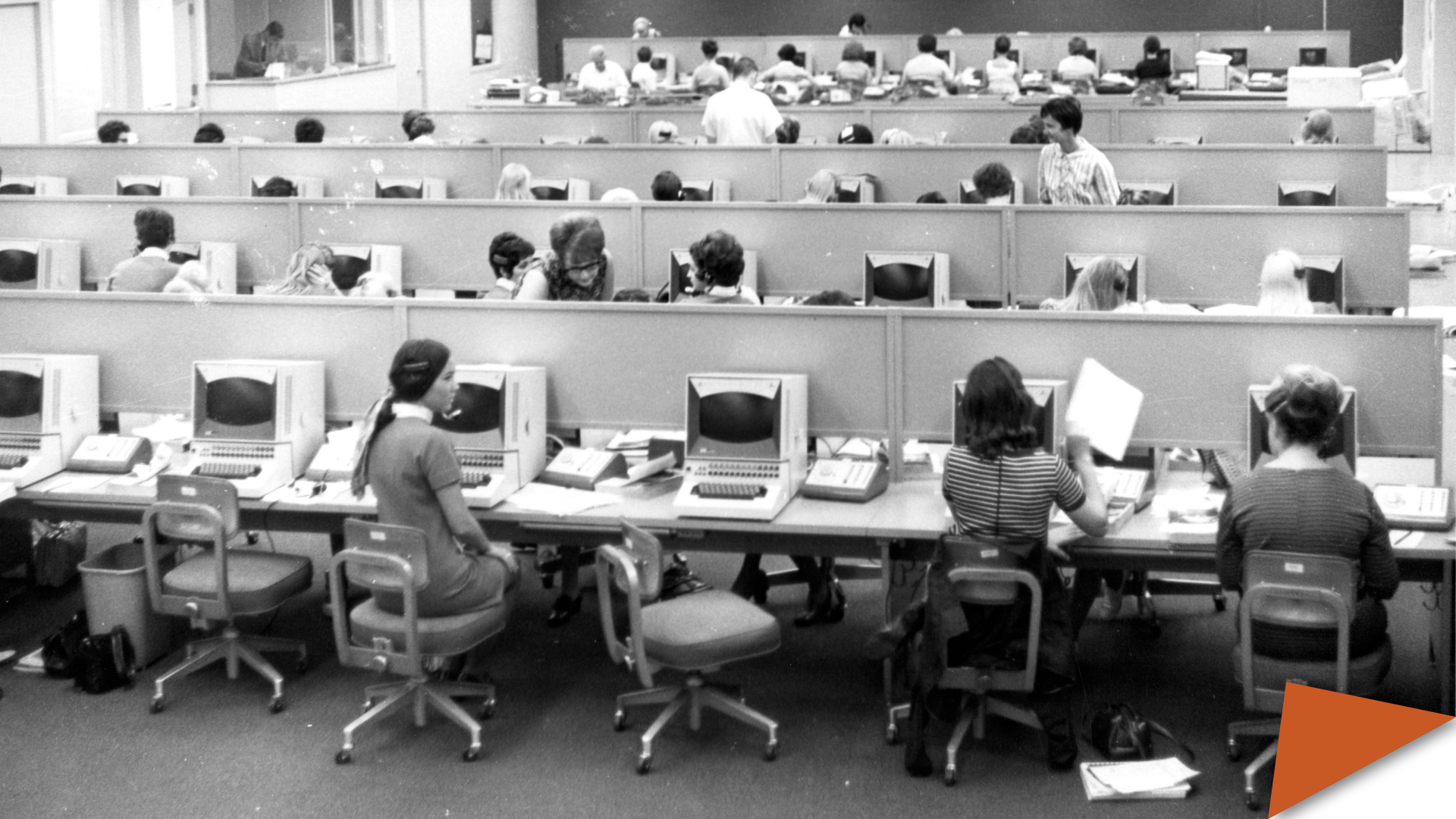 People working in a large computer room, ca. 1960s.