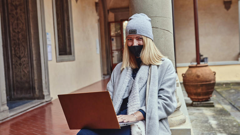 Researchers working on notebook with mask