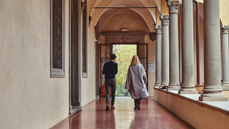 Researchers walking away in cloister badia