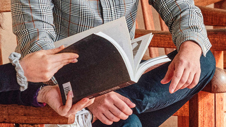 closeup-of-students-helping-eachother-looking-at-a-book