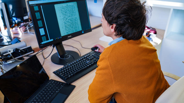 researcher-studying-notes-on-fixed-pc