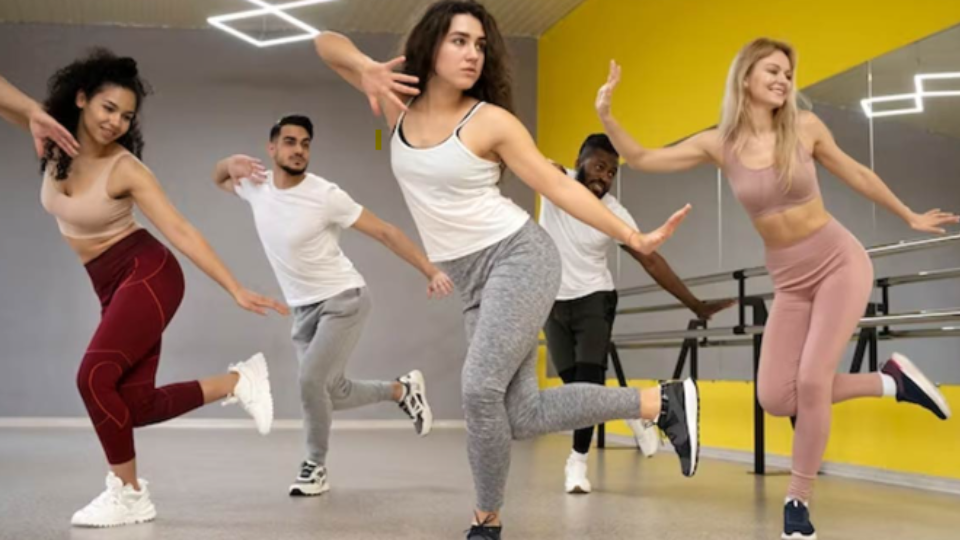 Group od 5 people dancing zumba in a dance studio